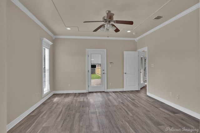 spare room with ceiling fan, ornamental molding, and light wood-type flooring