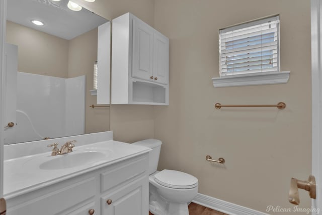 bathroom with vanity, toilet, and hardwood / wood-style floors