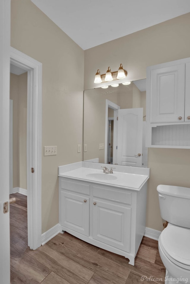 bathroom featuring vanity, hardwood / wood-style flooring, and toilet