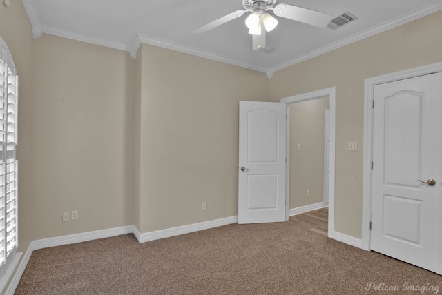 unfurnished bedroom with ornamental molding, light carpet, and ceiling fan