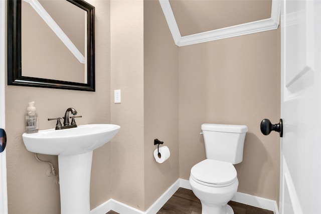 bathroom with hardwood / wood-style floors, ornamental molding, and toilet