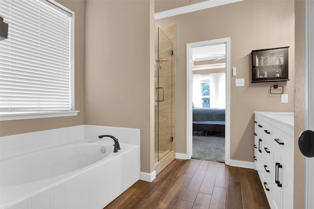 bathroom with vanity, hardwood / wood-style flooring, ornamental molding, and separate shower and tub