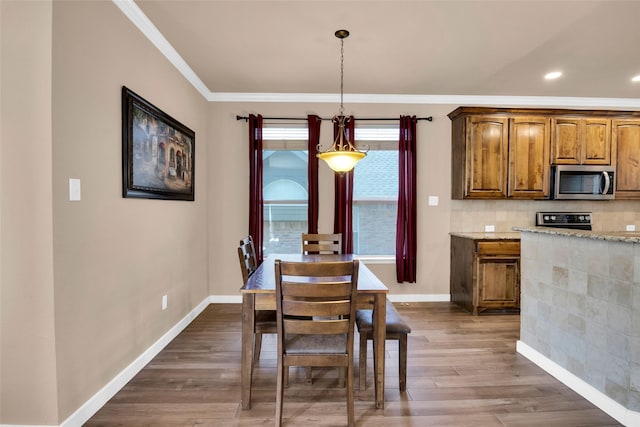 dining space featuring dark wood-type flooring and crown molding