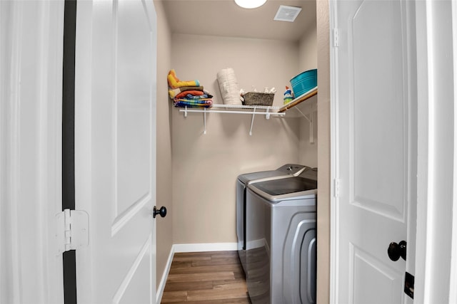 laundry room with washer and clothes dryer and light hardwood / wood-style floors