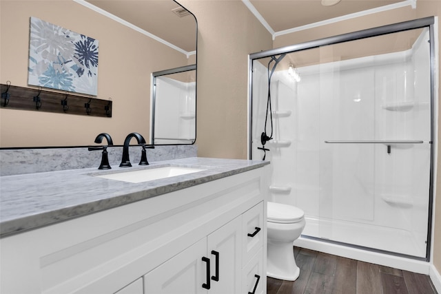 bathroom featuring hardwood / wood-style flooring, ornamental molding, vanity, walk in shower, and toilet