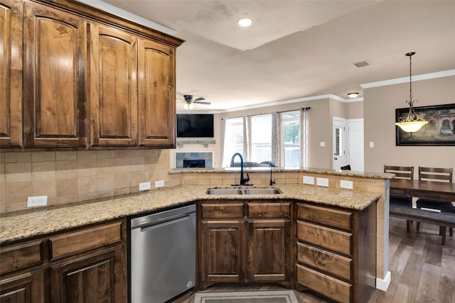 kitchen with sink, dishwasher, kitchen peninsula, light stone countertops, and backsplash