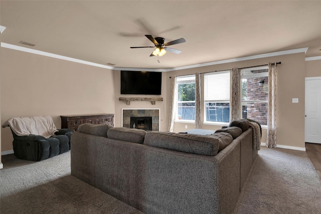 carpeted living room with crown molding, a fireplace, and ceiling fan