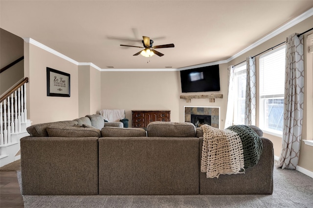 living room featuring ceiling fan, ornamental molding, and a fireplace