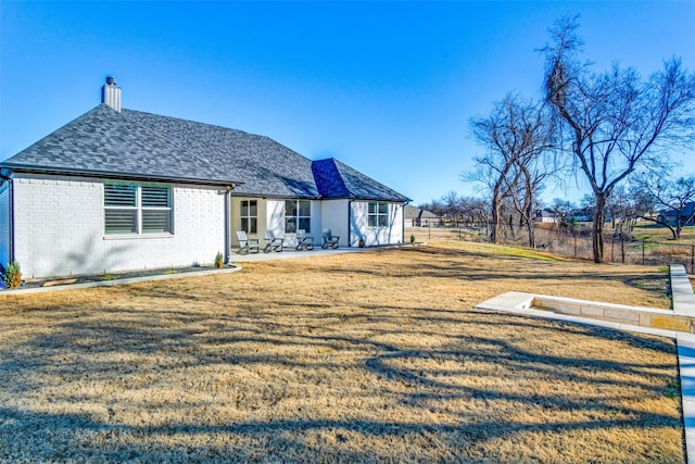 view of front of home with a patio and a front lawn