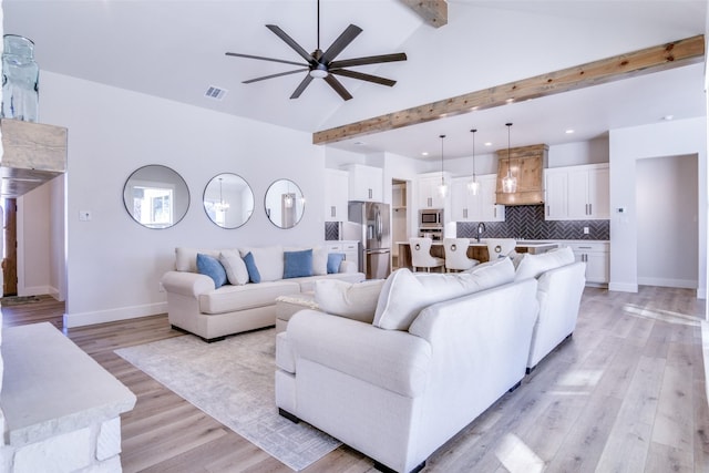 living room featuring sink, ceiling fan, beam ceiling, high vaulted ceiling, and light hardwood / wood-style floors