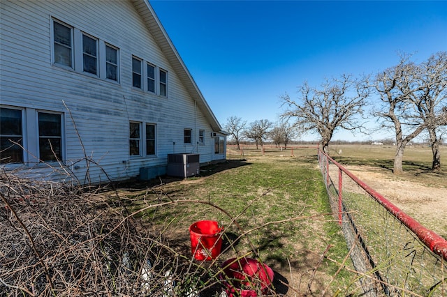 view of yard with a rural view, cooling unit, and fence