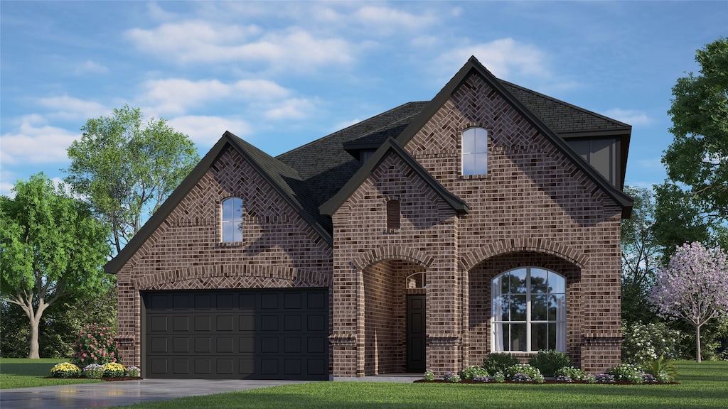 tudor house featuring a garage and a front yard