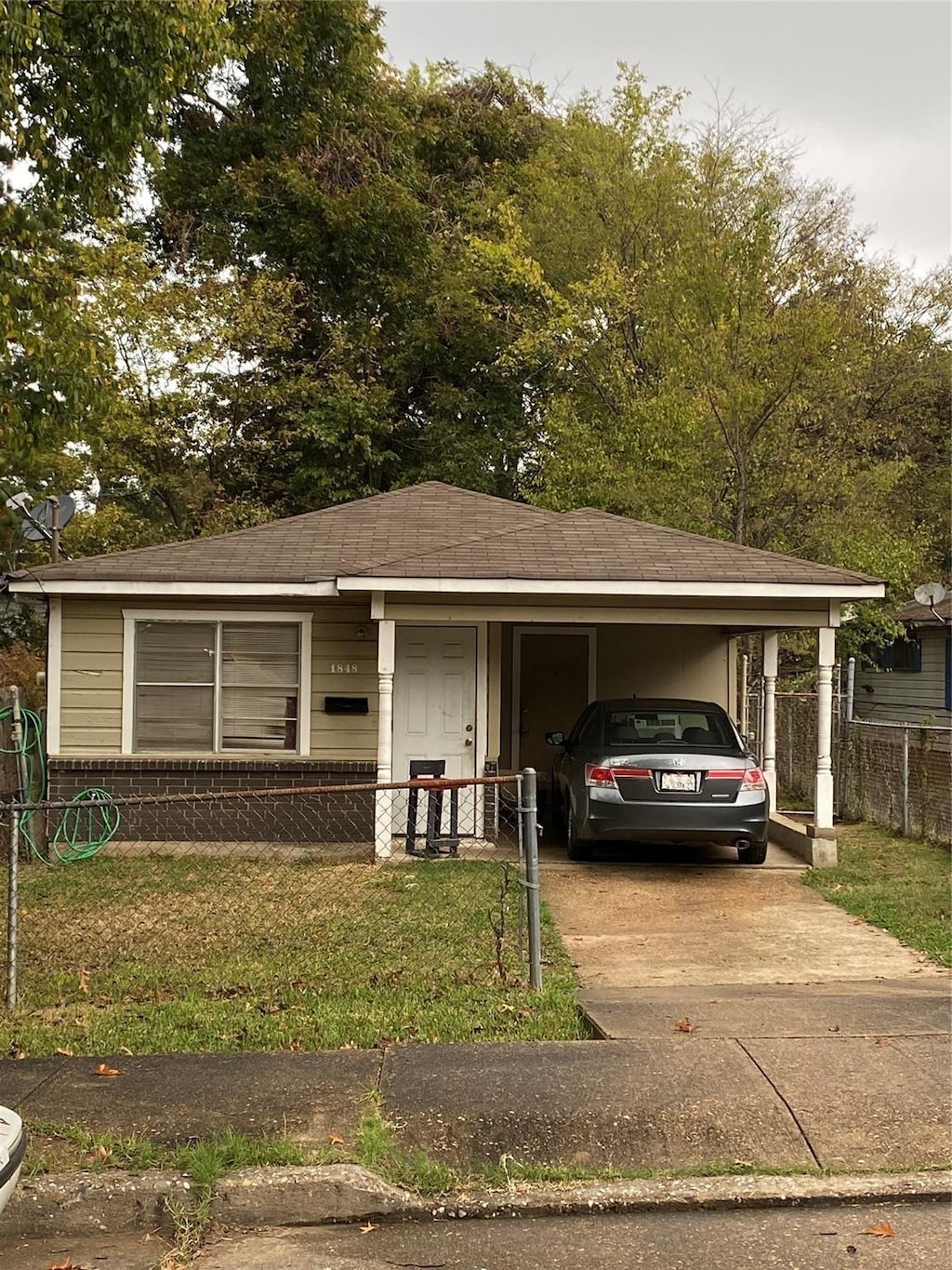 view of front facade with a carport and a front yard