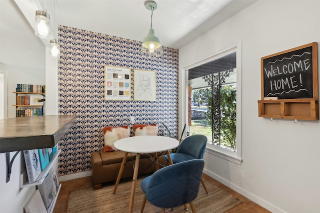 dining area with breakfast area, an accent wall, and baseboards