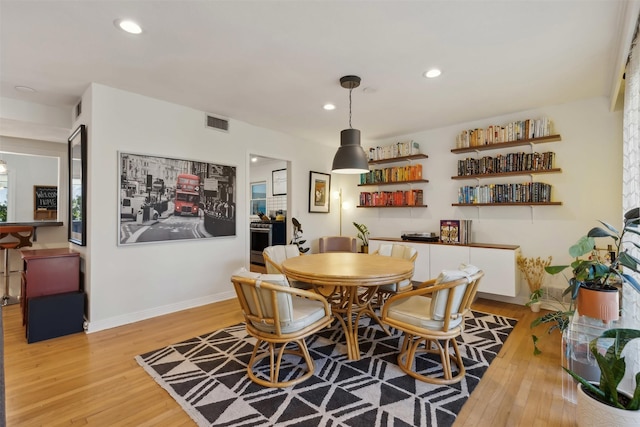 dining room featuring recessed lighting, baseboards, visible vents, and light wood finished floors