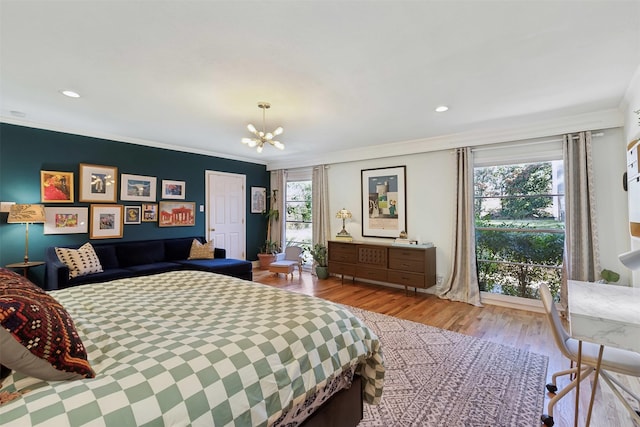 bedroom featuring ornamental molding, light wood-type flooring, and a chandelier