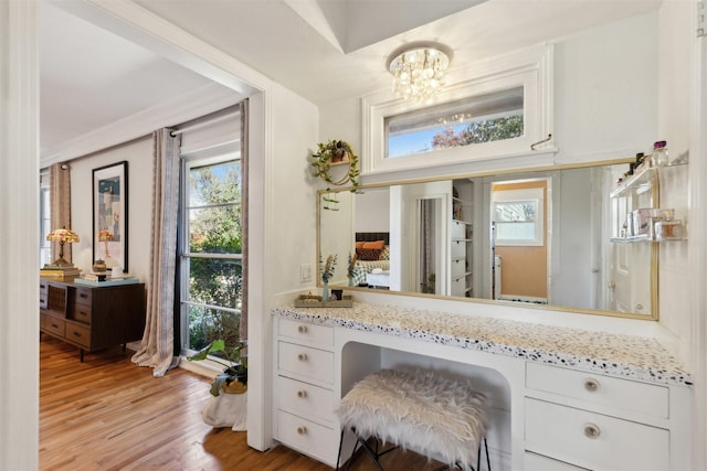 bathroom with vanity, hardwood / wood-style floors, and an inviting chandelier