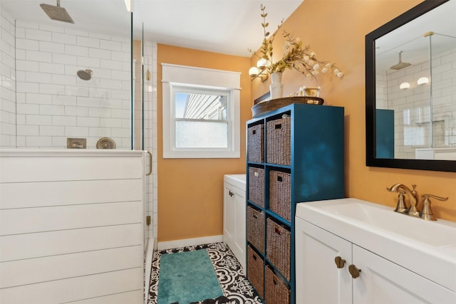 bathroom with baseboards, vanity, and a shower stall