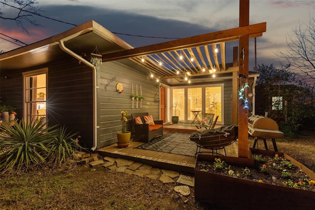 back house at dusk featuring a patio area