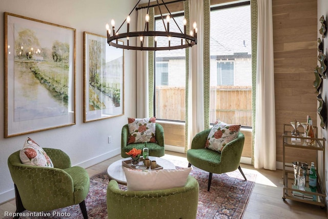 living area featuring hardwood / wood-style flooring, a chandelier, and wood walls