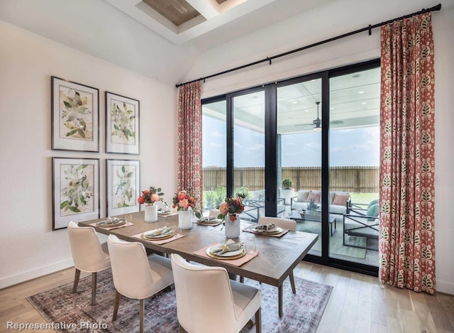 dining room featuring vaulted ceiling and light hardwood / wood-style flooring