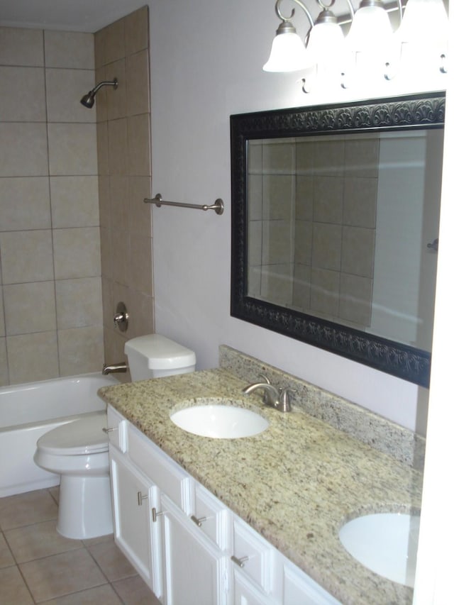 full bathroom featuring vanity, tiled shower / bath, tile patterned floors, and toilet