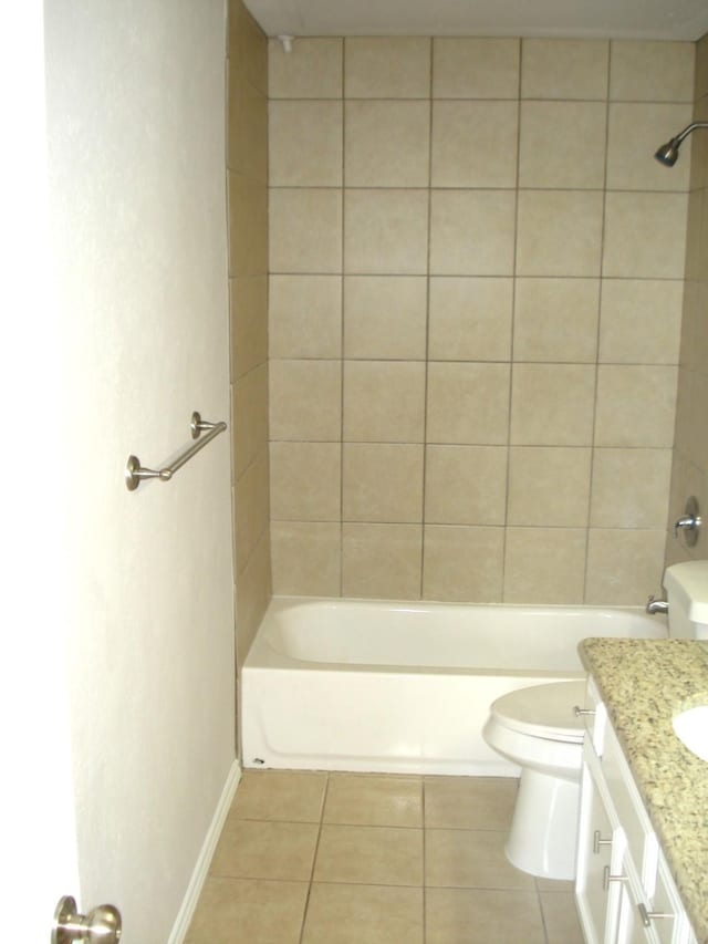 full bathroom with tile patterned flooring, vanity, tiled shower / bath, and toilet