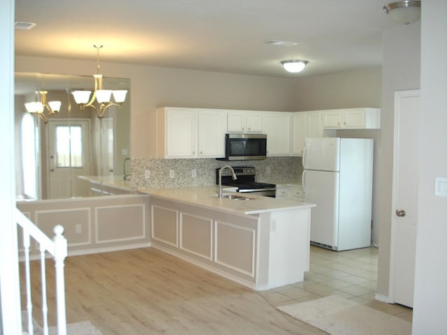 kitchen featuring white cabinetry, backsplash, stainless steel appliances, decorative light fixtures, and kitchen peninsula