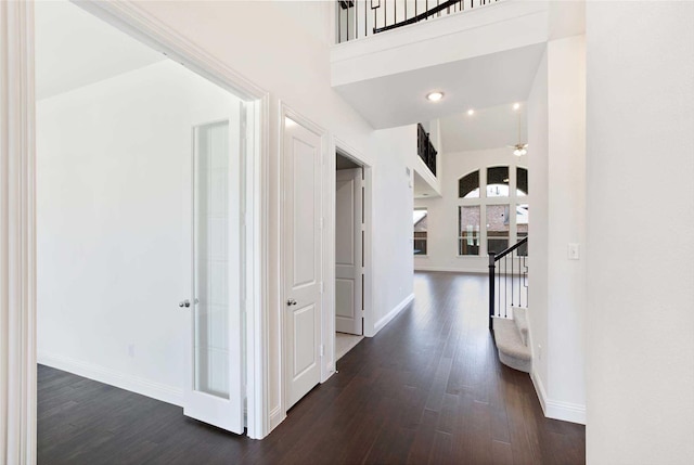 corridor featuring dark hardwood / wood-style flooring and a high ceiling