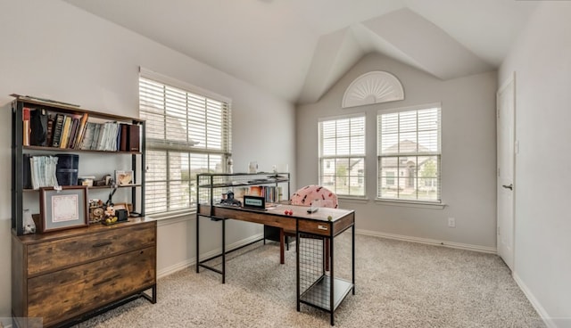 home office featuring lofted ceiling, light colored carpet, and a healthy amount of sunlight