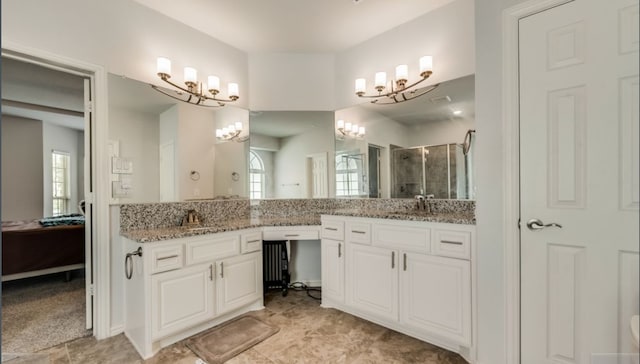 bathroom featuring vanity, a wealth of natural light, and a shower with shower door