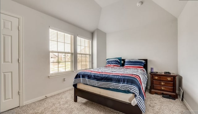 carpeted bedroom with lofted ceiling