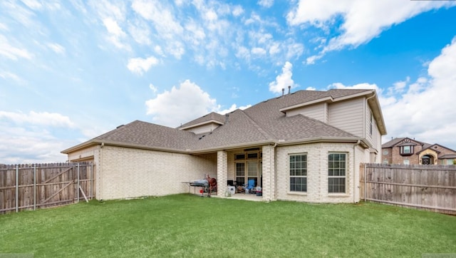 back of house featuring a patio area and a lawn