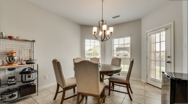 dining room featuring an inviting chandelier, a healthy amount of sunlight, and light tile patterned flooring