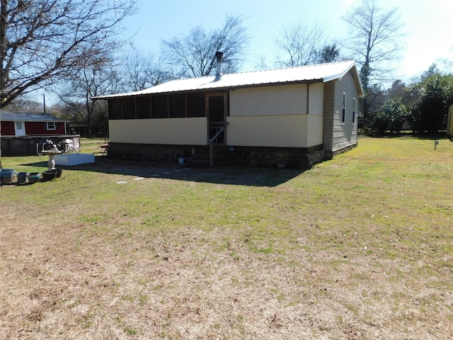 back of property featuring a lawn and a sunroom