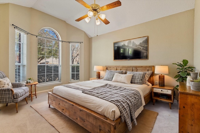 bedroom featuring ceiling fan, vaulted ceiling, and light carpet