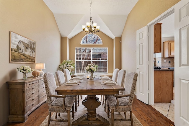 dining room with vaulted ceiling, light hardwood / wood-style flooring, and a notable chandelier