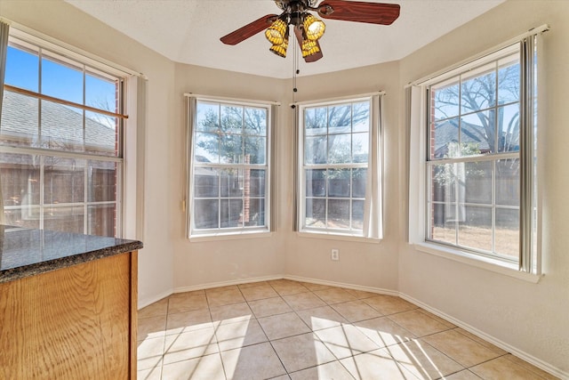 unfurnished sunroom with ceiling fan