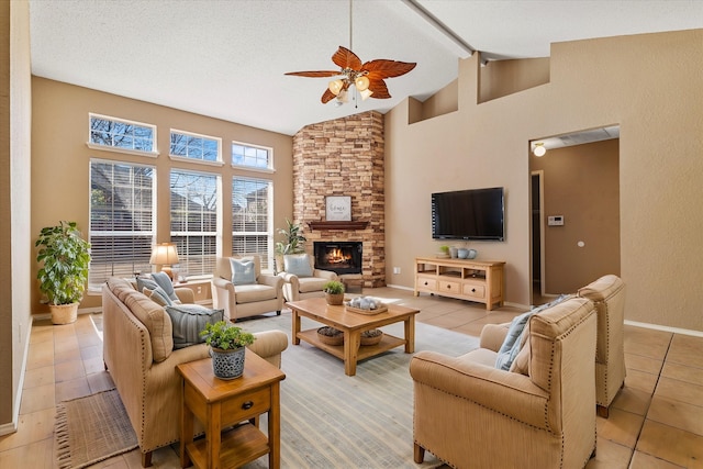 living room featuring ceiling fan, high vaulted ceiling, a textured ceiling, a stone fireplace, and beamed ceiling