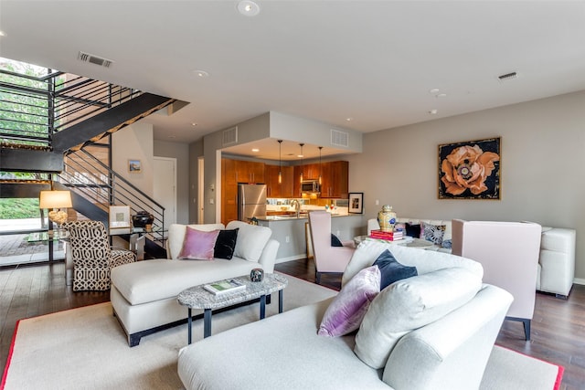 living area featuring stairway, dark wood-style flooring, visible vents, and recessed lighting