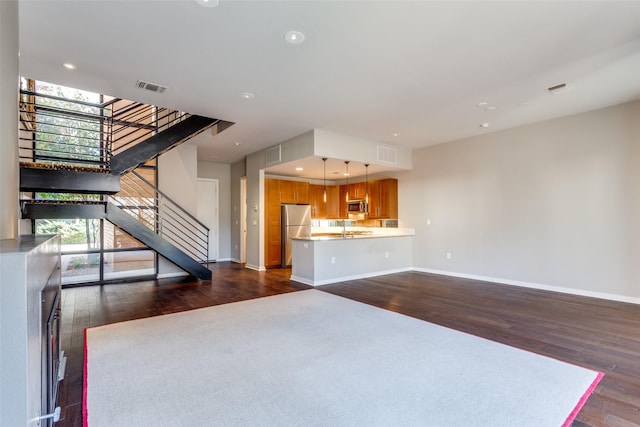 unfurnished living room with sink and dark hardwood / wood-style floors