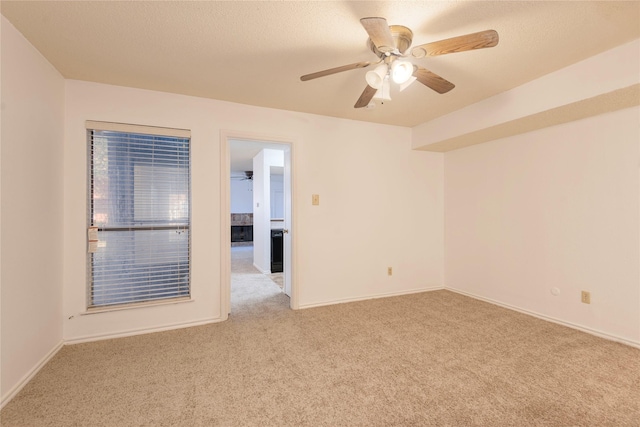 carpeted spare room featuring a textured ceiling and ceiling fan