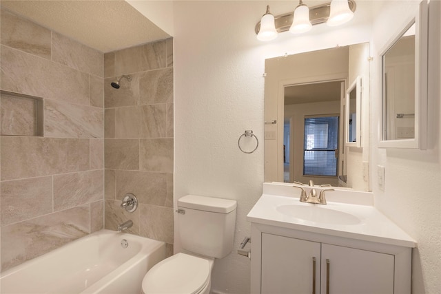 full bathroom with vanity, tiled shower / bath, and toilet