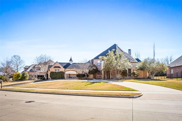 french provincial home featuring a front yard