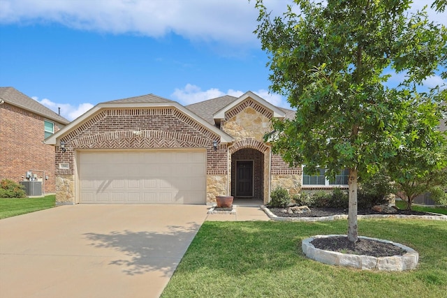 view of front of home featuring a garage, a front yard, and central air condition unit