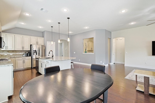 dining room featuring vaulted ceiling, dark wood-type flooring, and sink