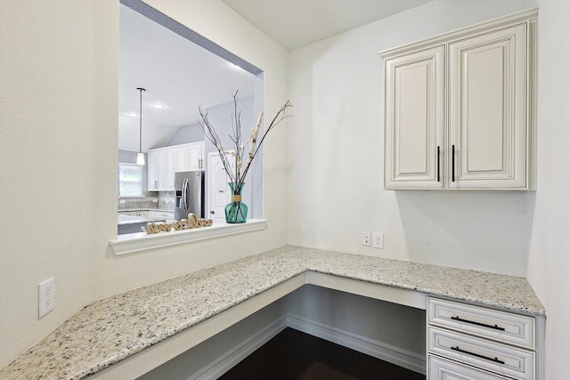 details featuring built in desk and stainless steel fridge