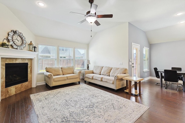 living room with ceiling fan, a fireplace, dark hardwood / wood-style floors, and vaulted ceiling