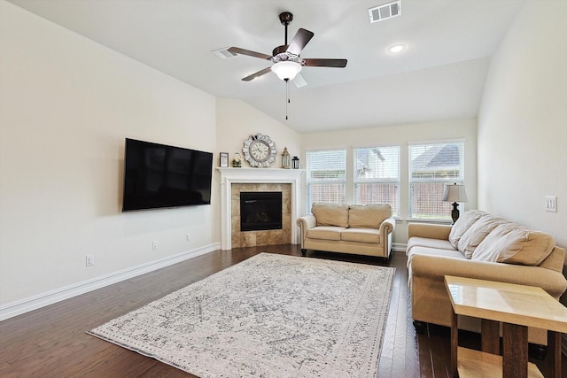 living room featuring ceiling fan, lofted ceiling, dark hardwood / wood-style floors, and a fireplace