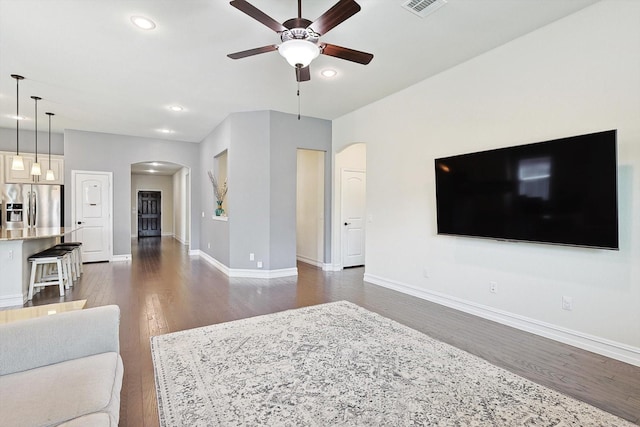 living room with dark wood-type flooring and ceiling fan